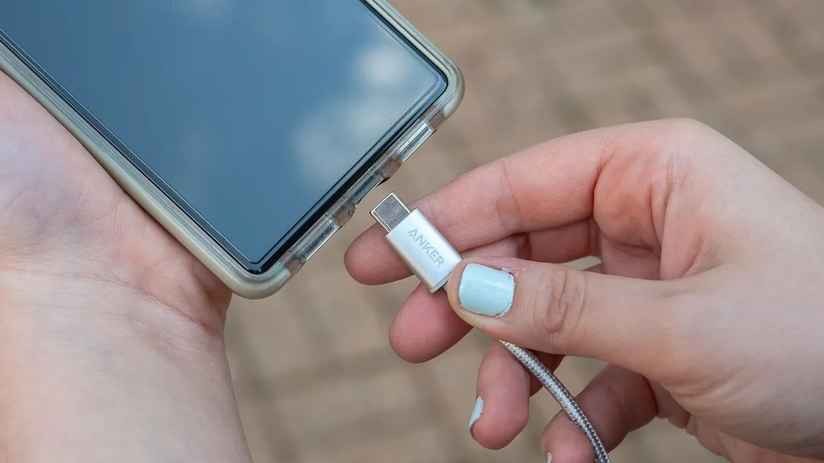 Người dùng cắm cáp USB-C vào điện thoại, minh họa sự tiện lợi và phổ biến của chuẩn sạc có dây này
