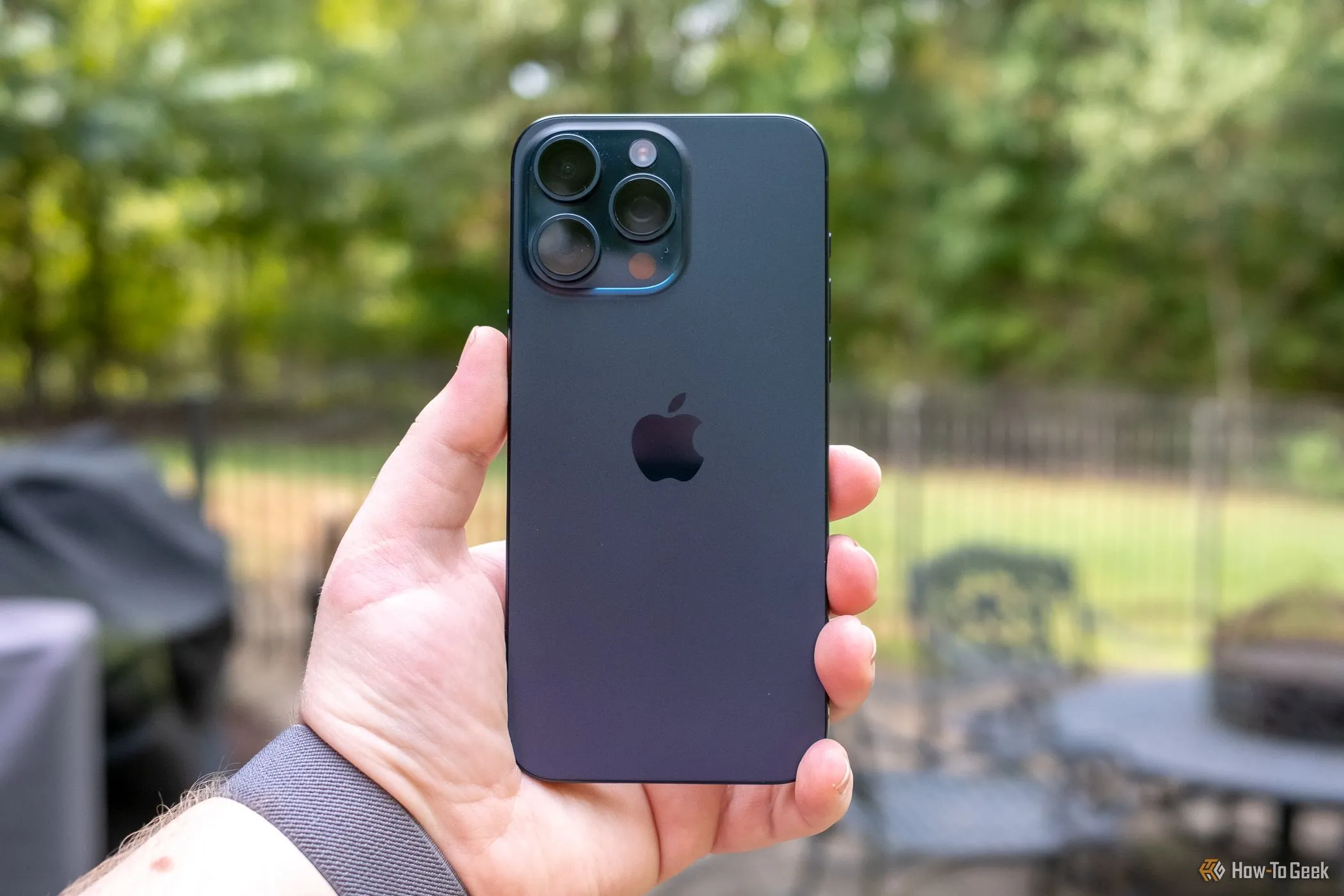 Người dùng cầm iPhone 15 Pro Max, thể hiện trải nghiệm camera cao cấp và kỳ vọng nâng cấp camera trên iPhone 17