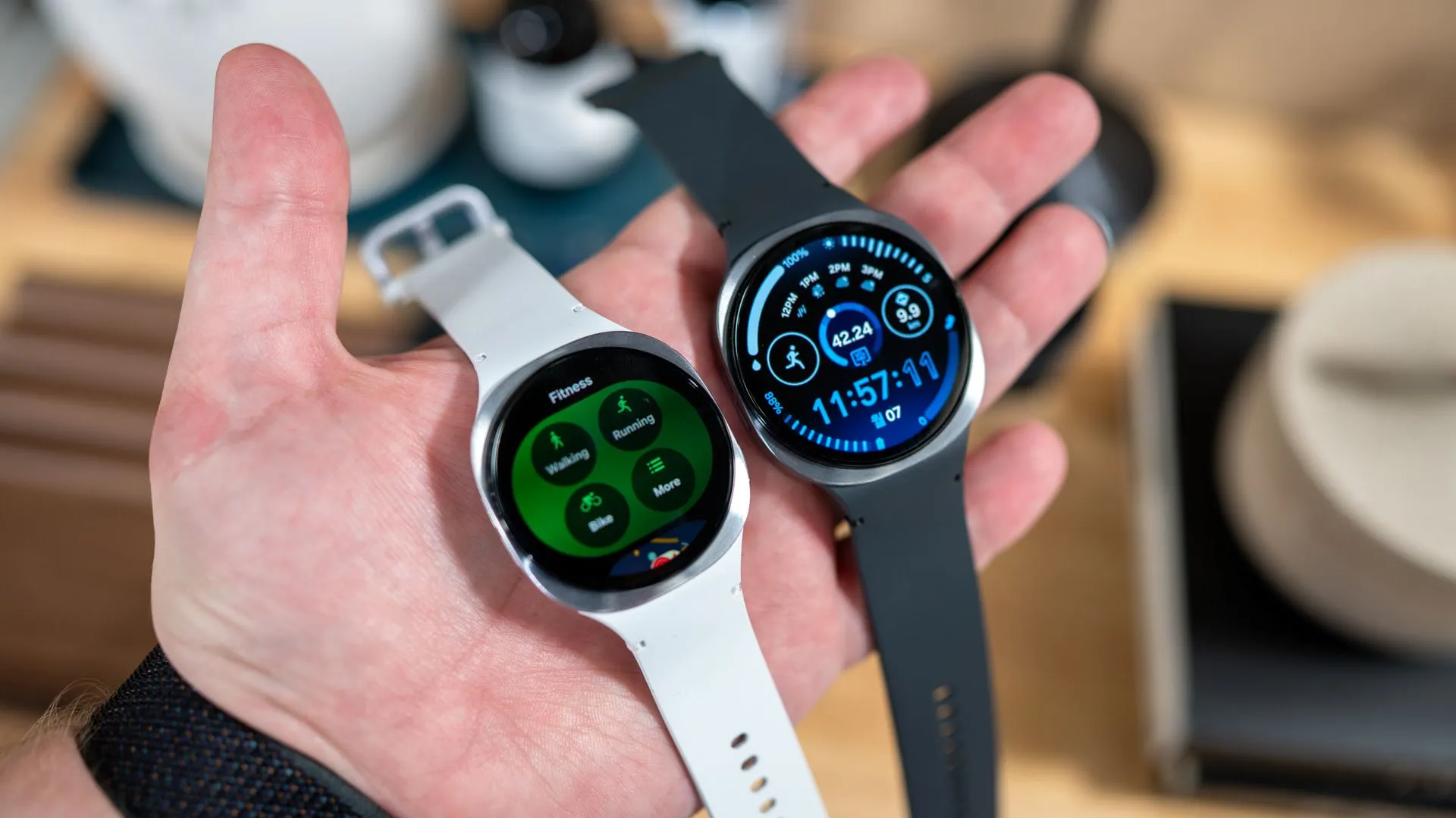 Người dùng đang cầm hai phiên bản Samsung Galaxy Watch 8 40mm và 44mm, cho thấy kích thước khác biệt