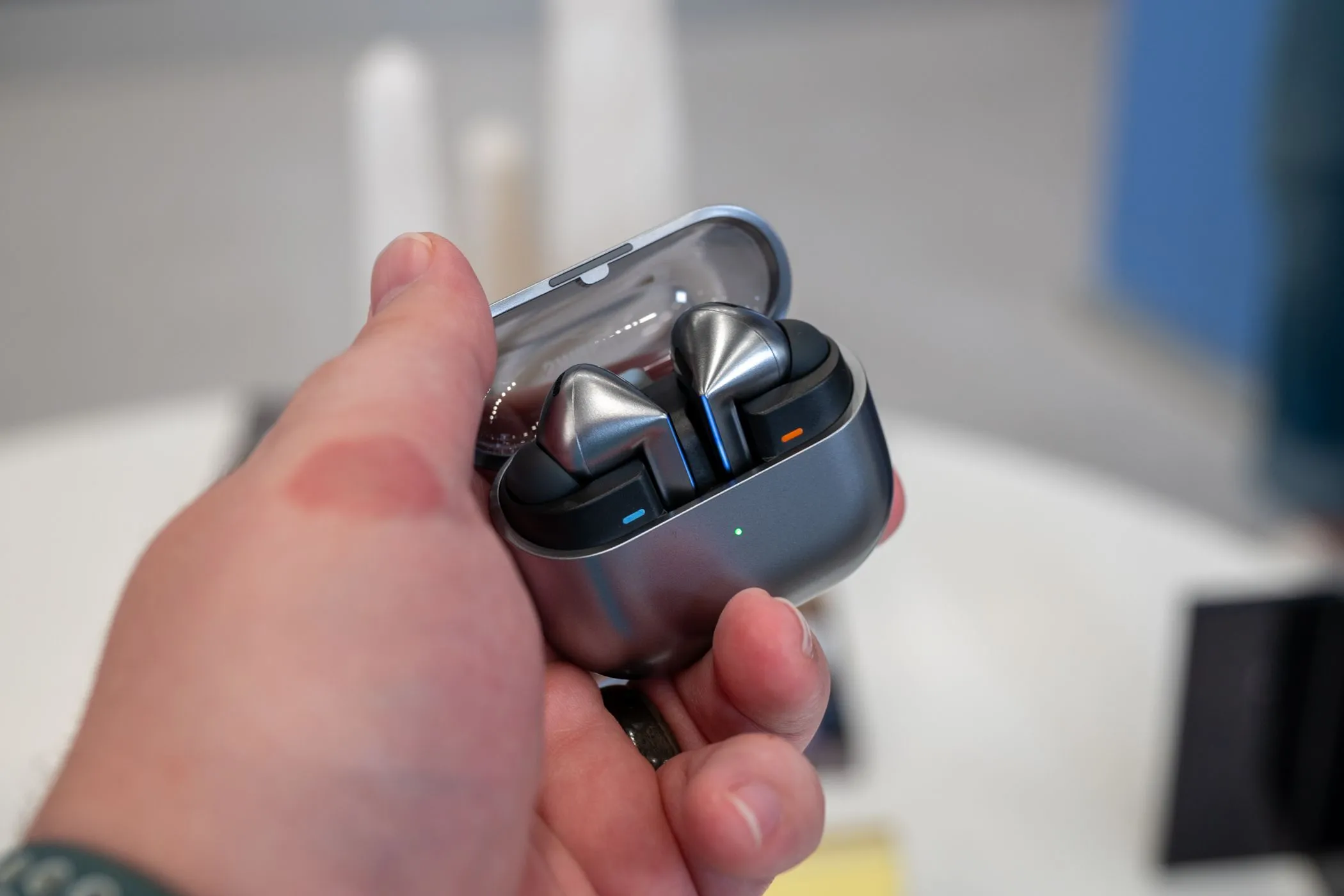 Người dùng đang cầm hộp sạc mở nắp của tai nghe Samsung Galaxy Buds 3 Pro, cho thấy thiết kế và hai phiên bản Buds 3