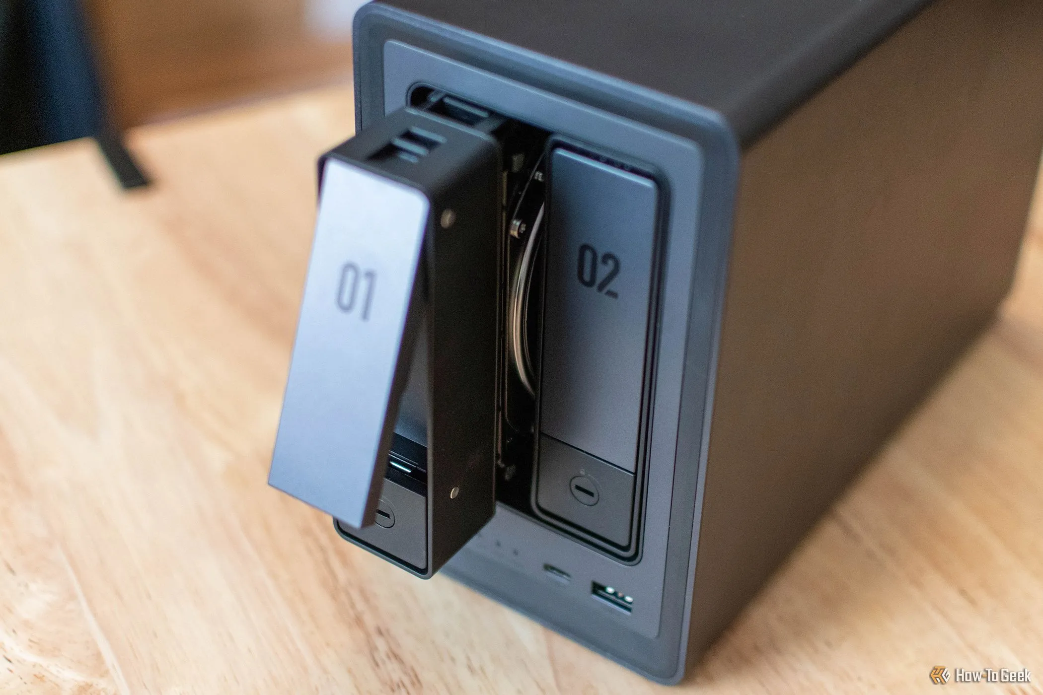 Ổ cứng NAS UGREEN NASYNC DXP2800 với một khoang ổ đĩa đang được tháo ra, minh họa khả năng mở rộng hạn chế cho Plex server.