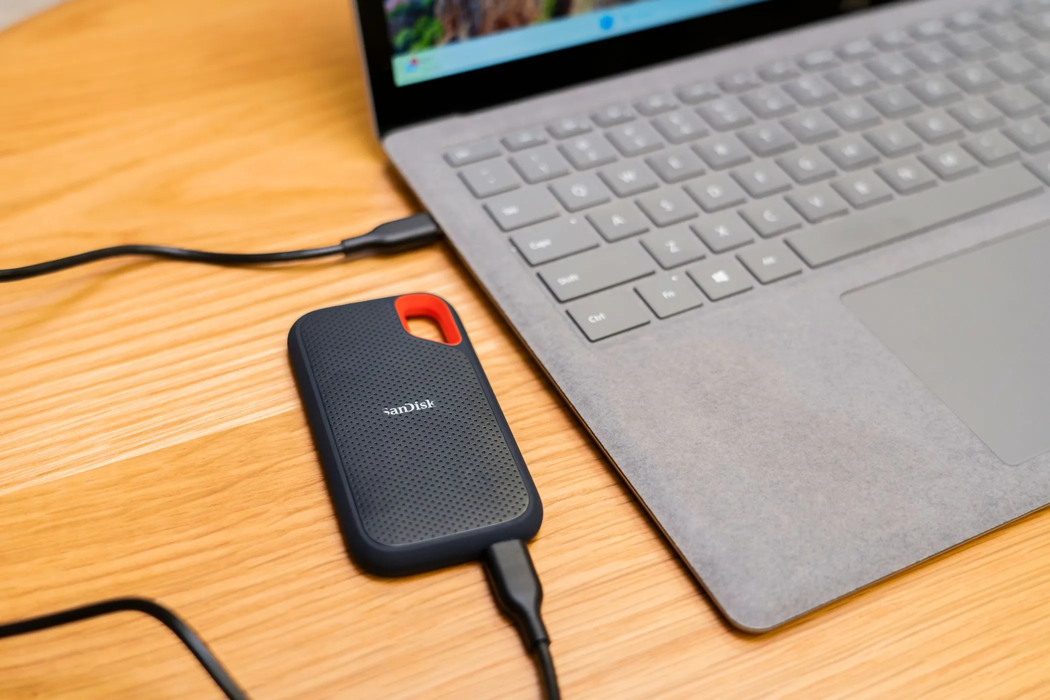 Ổ SSD di động nhỏ gọn kết nối với laptop qua cổng USB, minh họa giải pháp lưu trữ dữ liệu offline tiện lợi