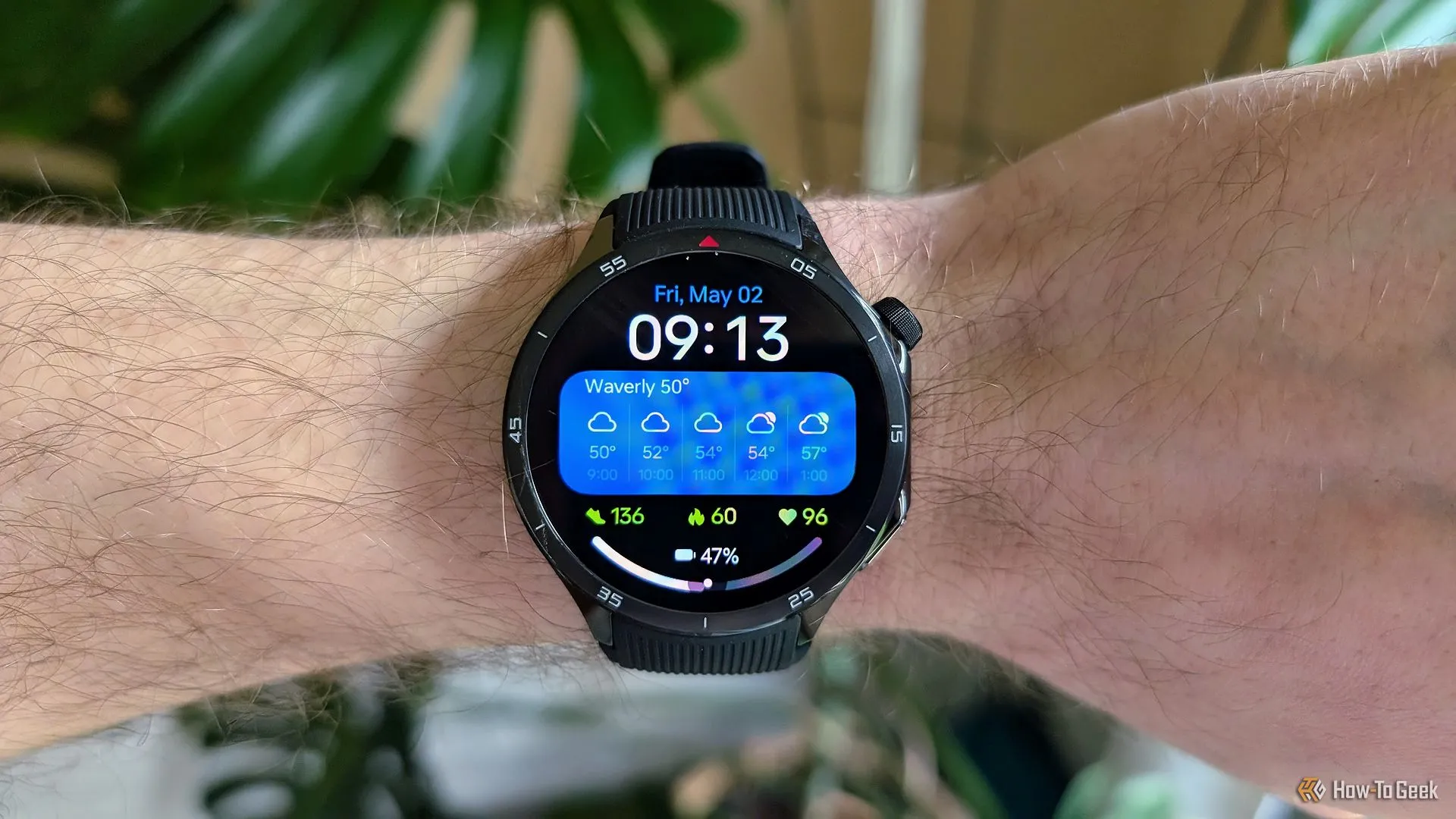 OnePlus Watch 3 trên cổ tay với màn hình bật, hiển thị màu sắc.