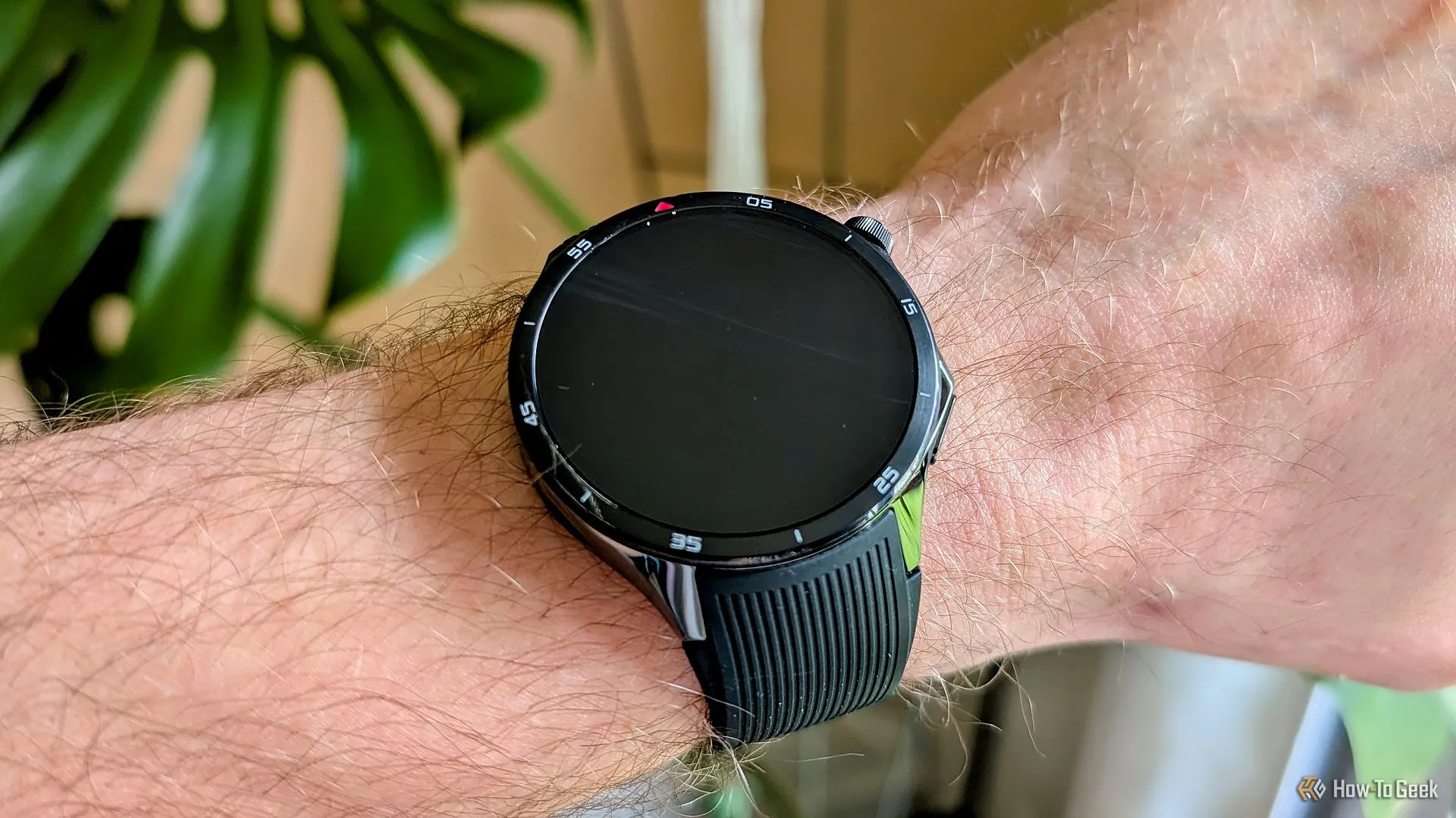 OnePlus Watch 3 trên cổ tay với màn hình tắt, nút xoay.