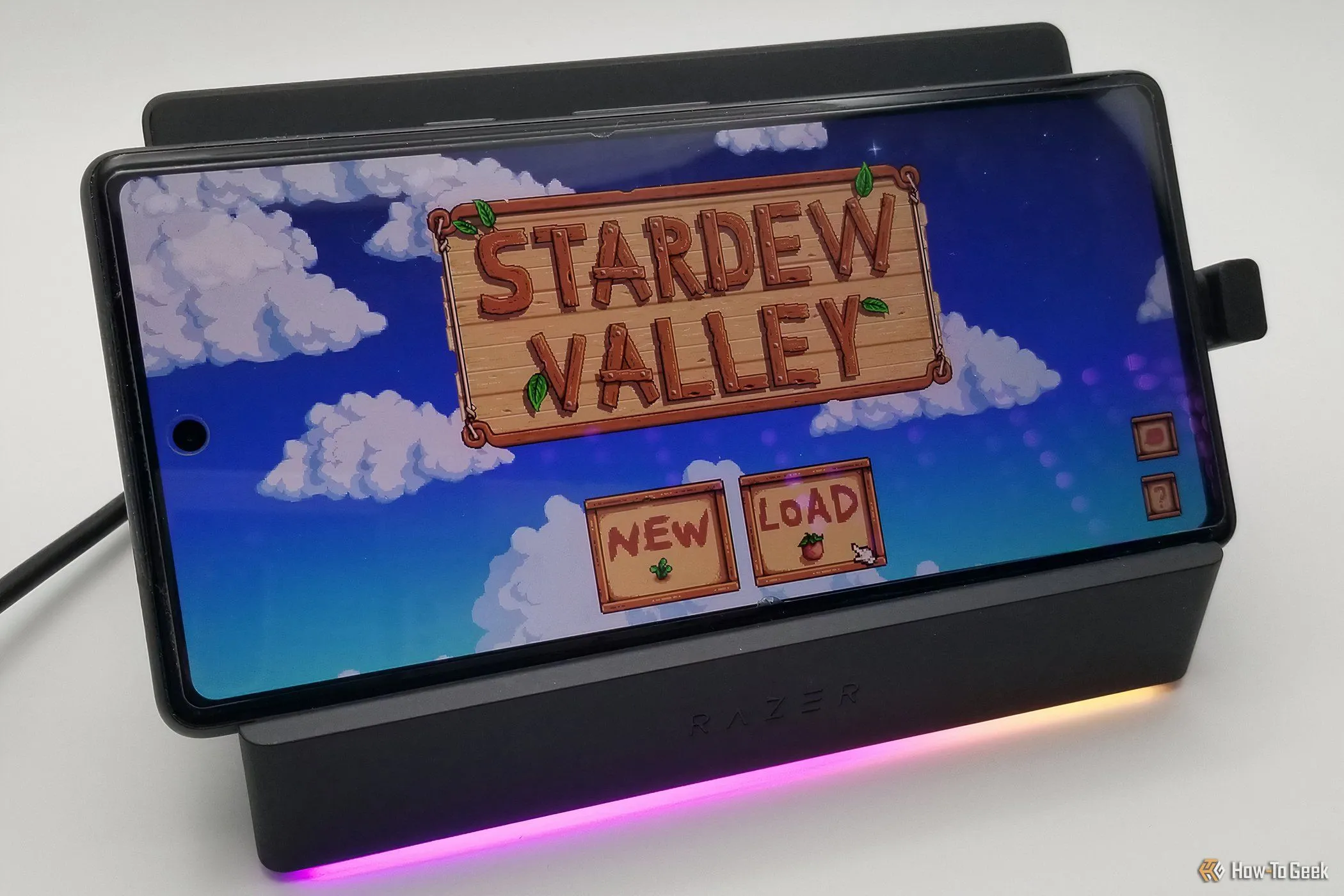 Razer Handheld Dock Chroma đang kết nối với một điện thoại thông minh, hiển thị trò chơi di động trên màn hình