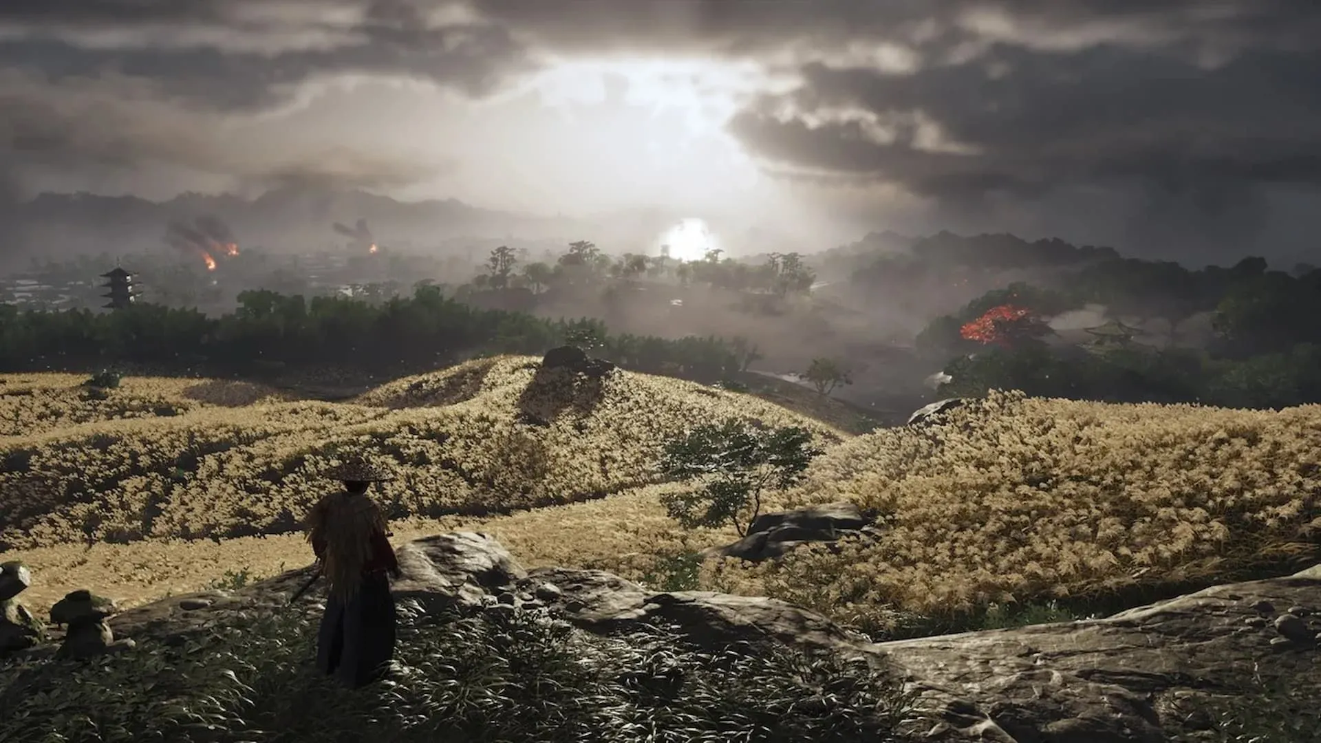 Samurai Jin Sakai đứng trên cánh đồng rộng lớn dưới bầu trời u ám trong Ghost of Tsushima, thể hiện thế giới mở tuyệt đẹp của game.