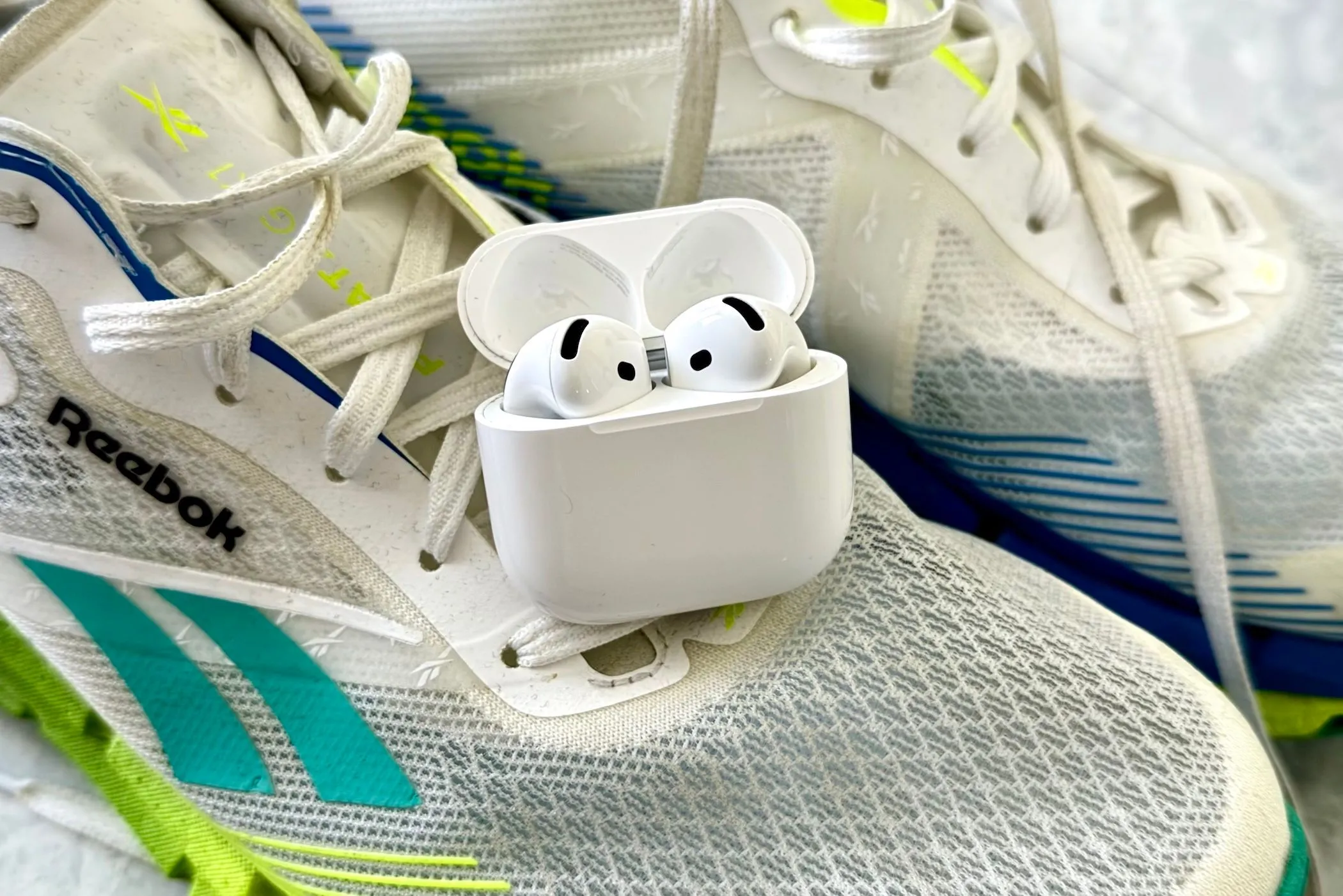 Tai nghe AirPods 4 và giày chạy bộ, biểu tượng cho việc tập luyện với Apple Watch