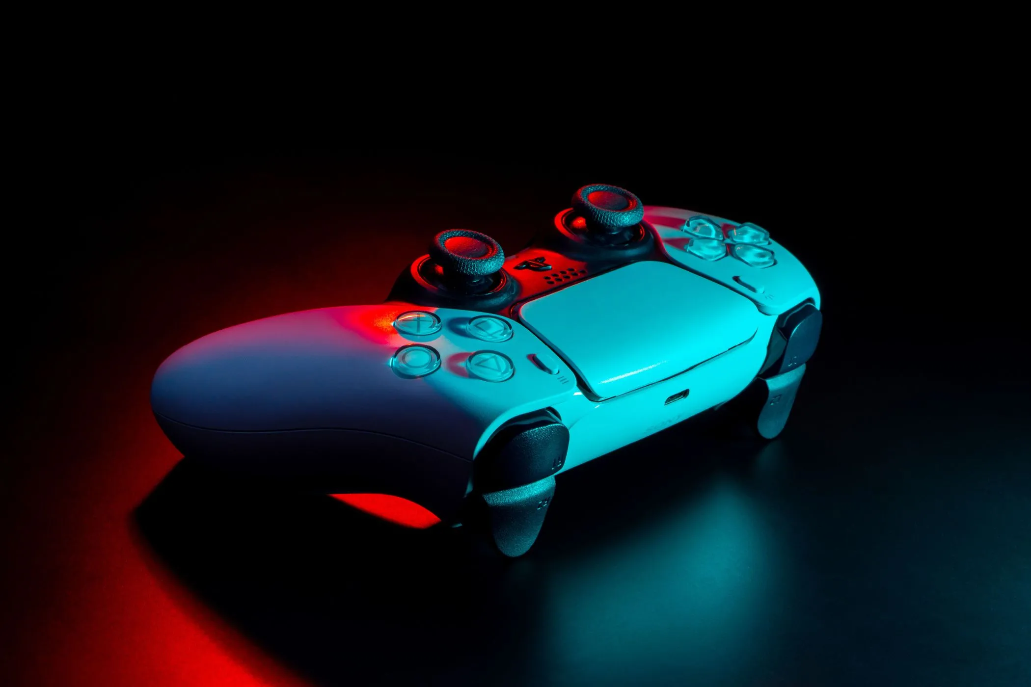 Tay cầm DualSense PS5 dưới ánh đèn neon lung linh, gợi nhớ niềm đam mê chơi game bị bỏ lỡ.