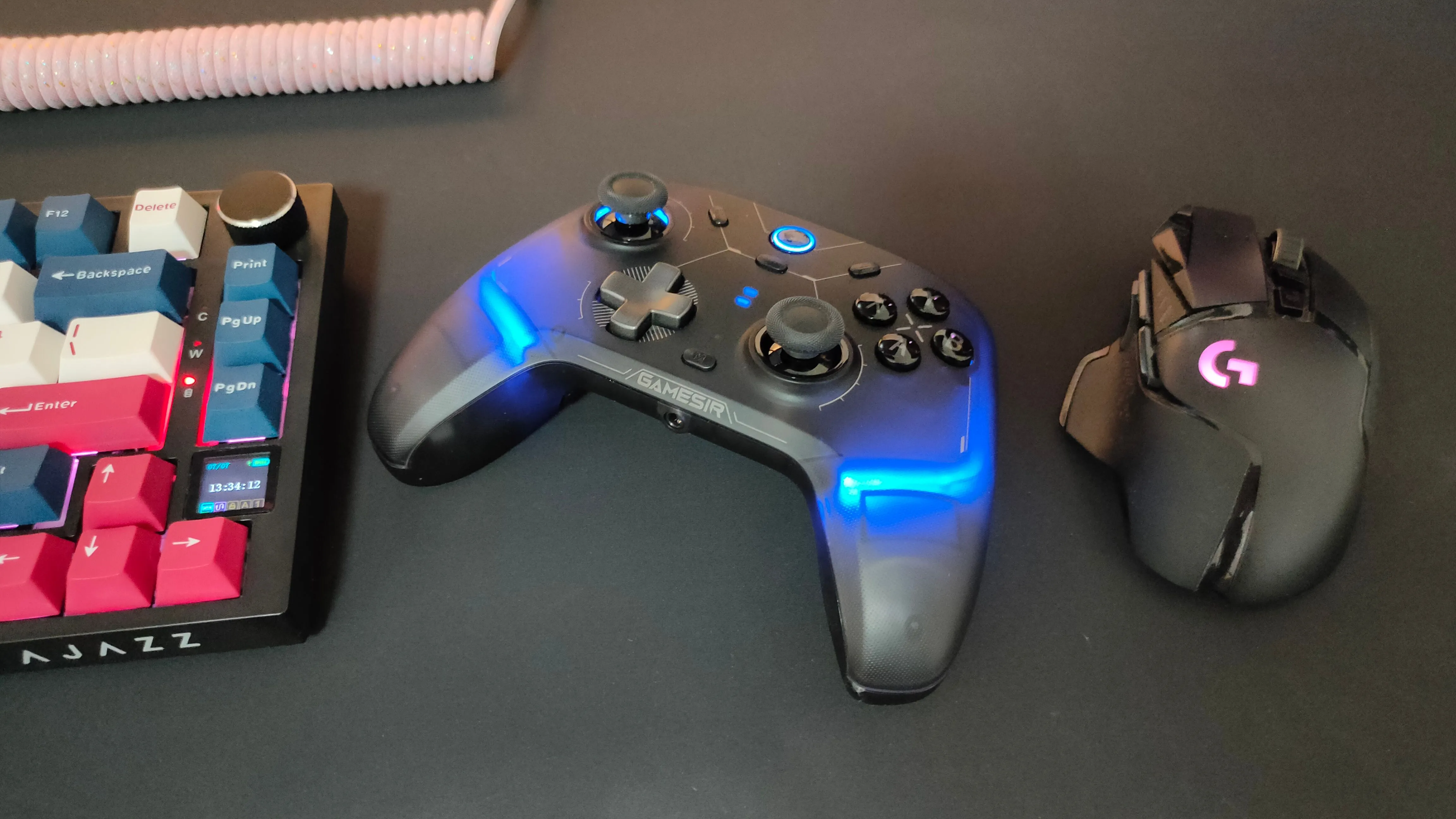 Tay cầm GameSir Cyclone 2 đặt cạnh chuột Logitech G502 và bàn phím cơ, cho thấy sự linh hoạt khi chơi game