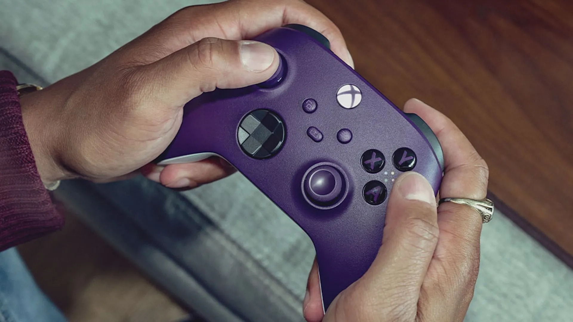 Tay cầm không dây Xbox Core màu tím được game thủ sử dụng, cho thấy sự thoải mái và thiết kế đặc trưng của Xbox.