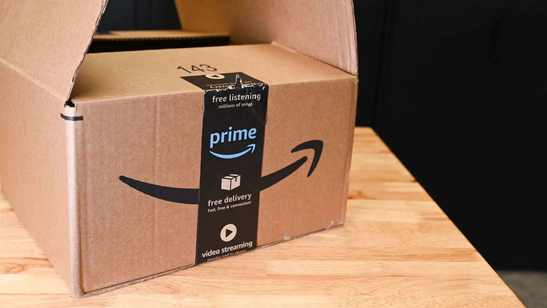 Thùng hàng Amazon, biểu tượng của chuỗi cung ứng và ảnh hưởng thuế quan đến giá cả sản phẩm công nghệ.