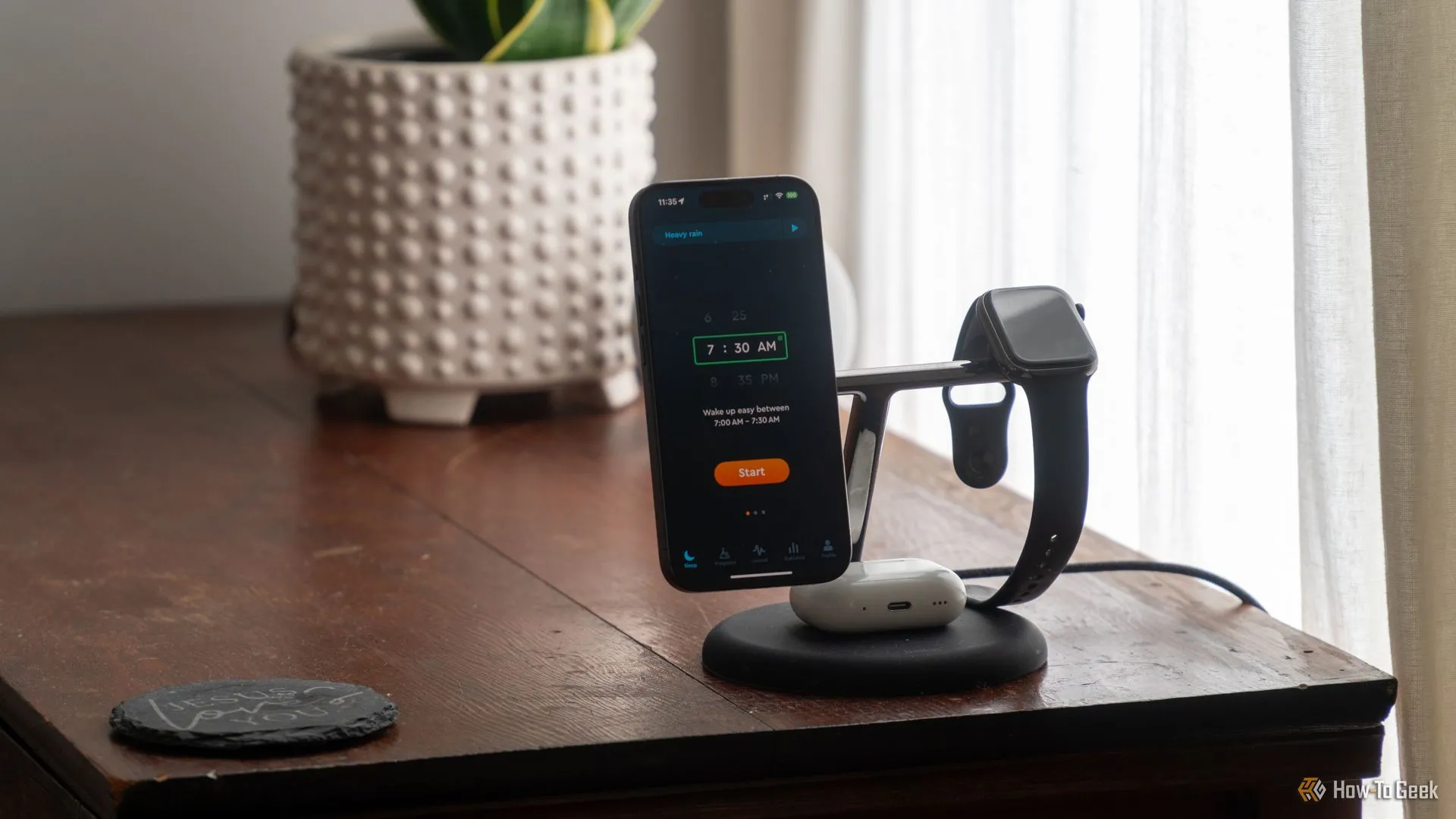 Ứng dụng Sleep Cycle trên iPhone 15 Pro đang sạc cạnh Apple Watch và AirPods Pro