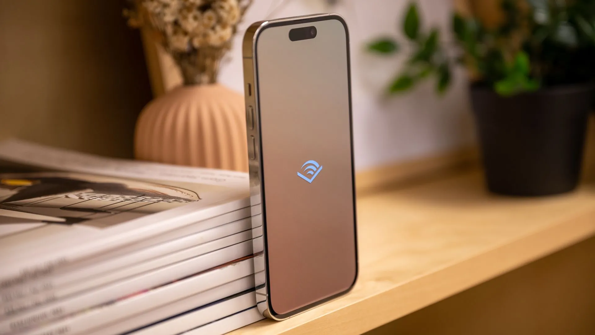 Cạnh trái iPhone 14 Pro hiển thị logo Audible trên màn hình, cho thấy trải nghiệm nghe sách nói trên thiết bị Apple di động.