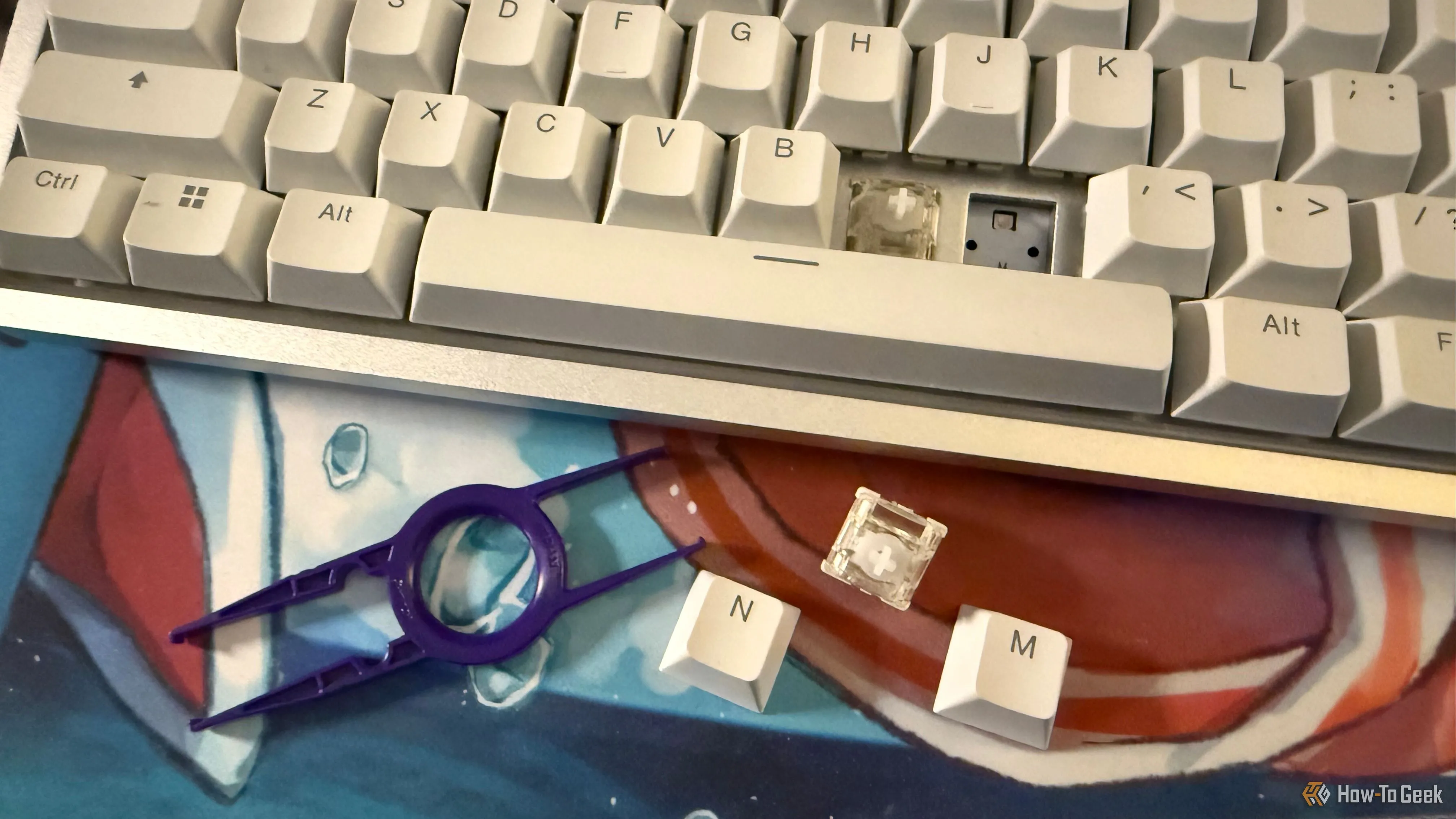 Bàn phím NZXT Function Elite MiniTKL đã tháo keycap và switch từ tính, cùng với dụng cụ gỡ keycap và switch