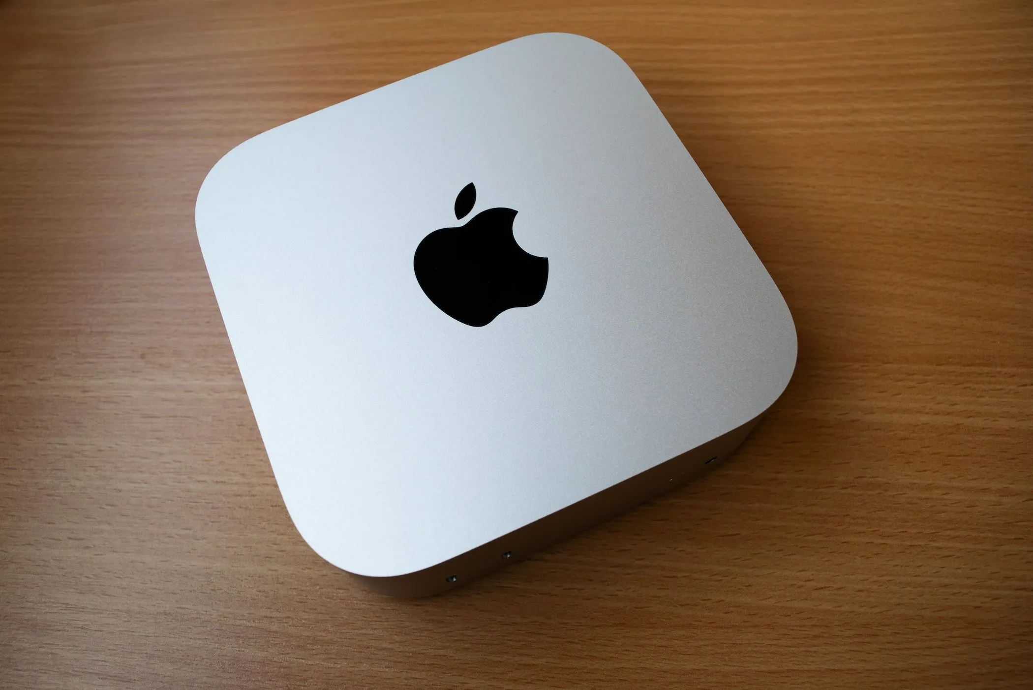 Chiếc Mac Mini M4 đặt trên bàn gỗ, thể hiện sự nhỏ gọn và mạnh mẽ.