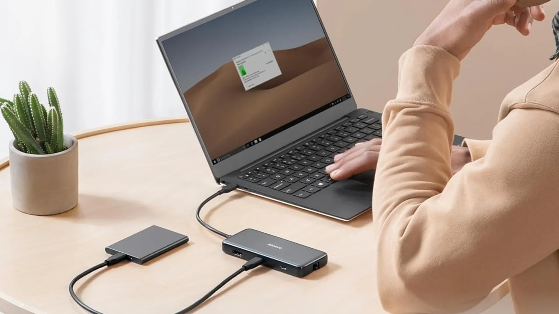 Hub USB-C Anker 555 8-in-1 trên bàn làm việc, cắm vào laptop