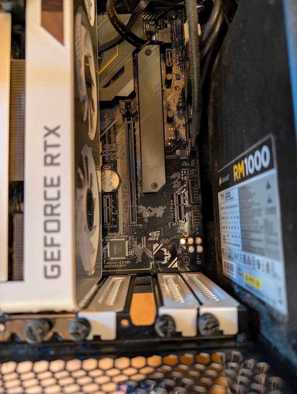 Nội thất bên trong một bộ máy tính để bàn, hiển thị các thành phần chính và khe cắm PCIe trống.