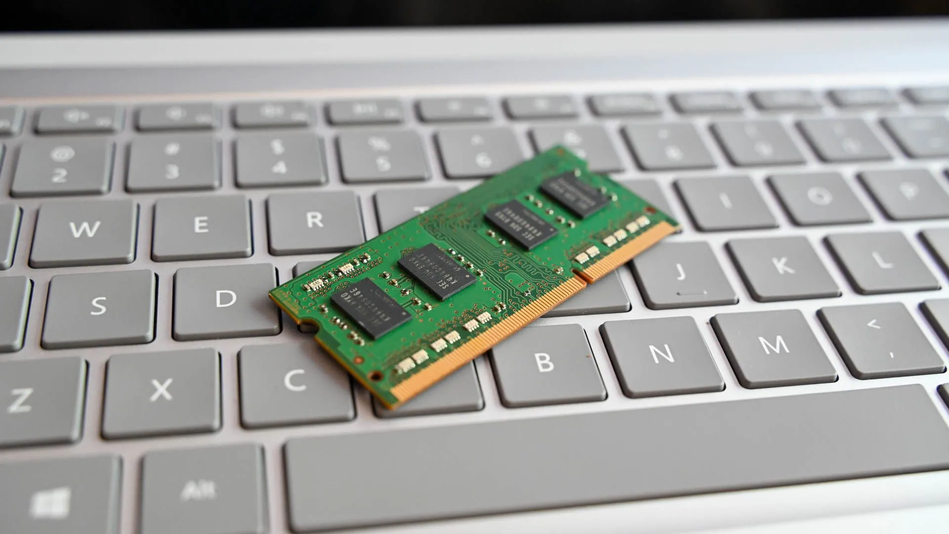 Thanh RAM máy tính đặt trên bàn phím laptop, tượng trưng cho nâng cấp phần cứng.